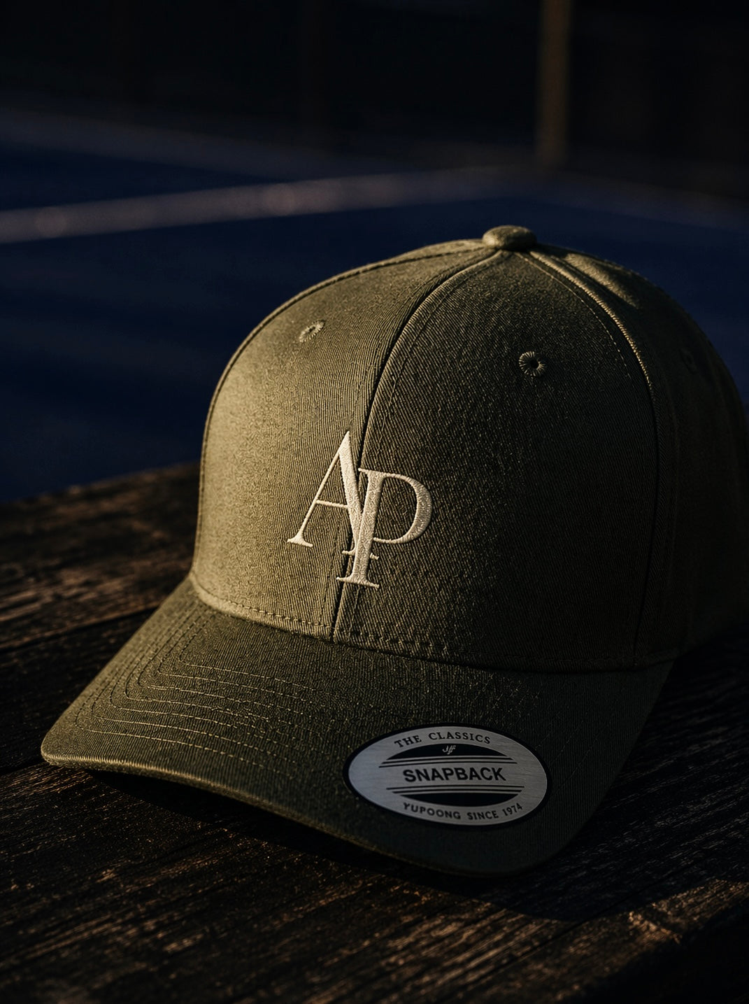 Green AP Club cap with a logo on a wooden surface