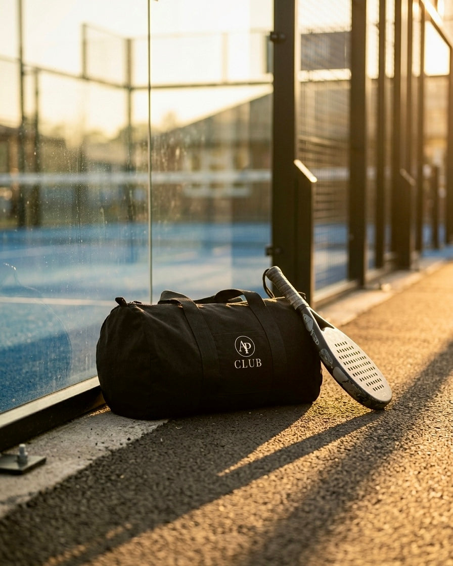 Black AP Club duffel bag with a paddle on a padel court surface