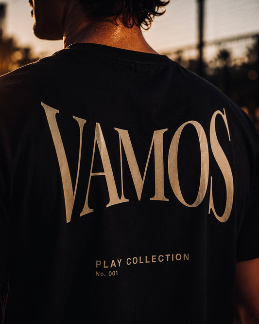 AP Club Vamos Tee (Play Collection No.001) – close-up back view of black t-shirt with gold 'VAMOS' graphic, British padel apparel.
